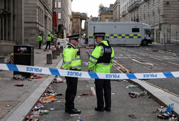 Police officers and emergency responders at the scene where a car plowed into crowds during Liverpool FC victory parade in May 2025
