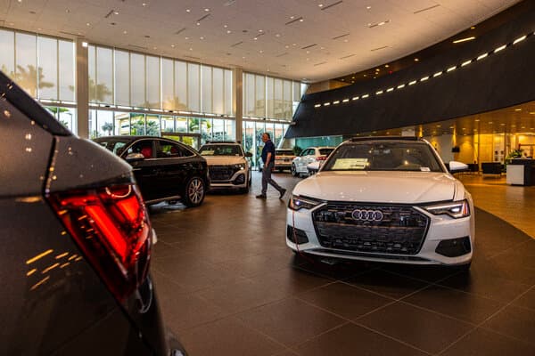 A row of shiny new luxury cars parked at a dealership.