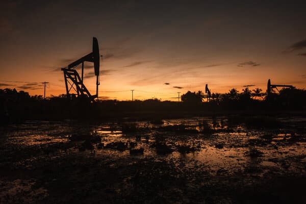 An oil rig operating in Venezuela under a cloudy sky, representing the challenges in reviving the nation's oil industry.