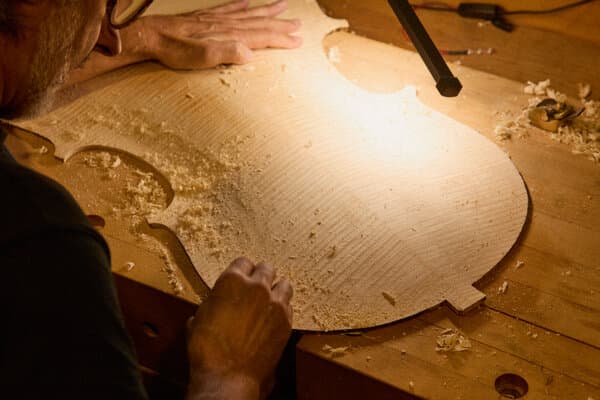 A pile of burnt violin wood and tools amidst the ashes of a workshop destroyed by the Eaton Fire.