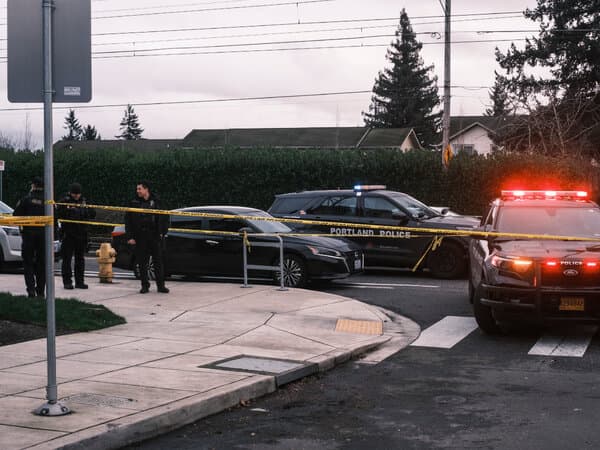 Crime scene tape and emergency vehicles in Portland, Oregon following a shooting incident involving Border Patrol agents.