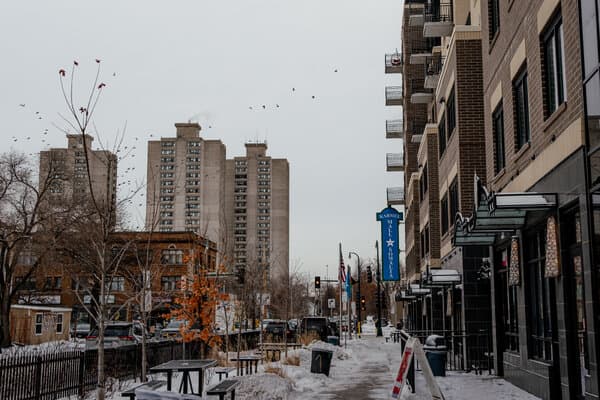 A crowded courtroom with refugees and attorneys reviewing legal documents related to their immigration cases in Minnesota