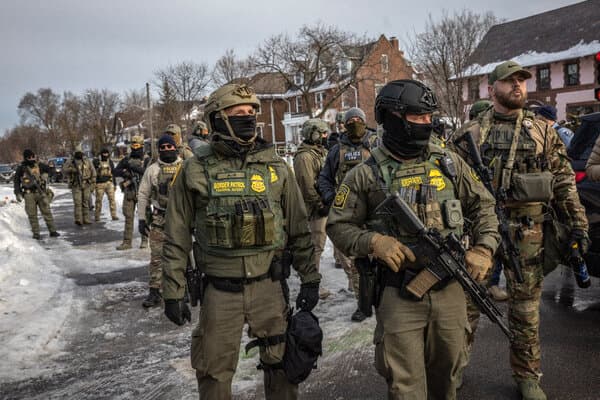 Federal agents and local police officers standing near a police barricade